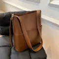 Detalle del bolso de hombro marrón con textura de alta calidad y correa elegante. - Café