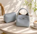 Elegante bolso de mano de cuero azul claro con cierre de giro y neceser a juego. - Azul
