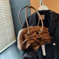 Chic sac à main marron en cuir verni avec nœud, élégant sac bandoulière style ballet. - Marron