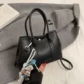 Bolso de mano de cuero negro con asas superiores y correa de hombro para uso diario. - L / Negro