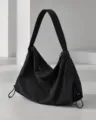 Primer plano detallado del bolso de hombro hobo de nailon negro con cremallera y cordones. - Negro