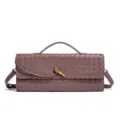 Close-up of the woven leather baguette bag showcasing intricate intrecciato texture and metal knot. - Taupe