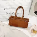 Elegante bolso de mano de ante marrón con asa superior para uso diario en la ciudad. - Marrón Esmerilado