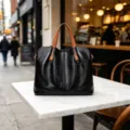 Elegante bolso de mano de cuero suave negro con asas marrones, ideal para uso diario. - Negro