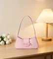 Pink patent leather shoulder bag, minimalist chic baguette style with bow detail. - Pink