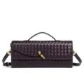 Detailed view of dark woven leather baguette bag with chic golden knot clasp and strap. - Grape Purple
