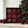 Rote Samt Weihnachtskugeln im edlen schwarzen Geschenkkarton, Detailaufnahme der Festtagsdeko. - Weinrot (ASSNR89-51)
