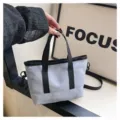 Gros plan détaillé du mini sac cabas bleu clair décontracté avec anses et bandoulière noirs. - Bleu