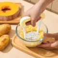Manual potato masher kitchen tool with ergonomic yellow handle for mashing potatoes and baby food. - Yellow