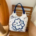 Cute canvas tote bag with blue monster graphic, casual large capacity shoulder bag for daily. - Sunflower