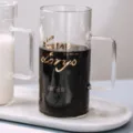 Transparante glazen koffiekop met handvat en gouden tekstprint voor thuis en op kantoor. - Gouden letters ontwerp (zonder deksel)