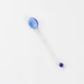 Jolie longue cuillère à café en verre transparent bleu avec des perles colorées à l'intérieur. - Cuillère bleue (avec granulés)