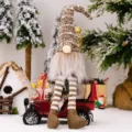Cute Christmas gnomes plush doll with striped knit hat sitting on vintage toy car - Brown
