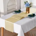 Vista dettagliata del runner da tavola in raso dorato, che mostra consistenza e bordi raffinati. - Champagne