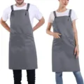 Adjustable polyester work apron with cross back and multiple pockets for restaurant staff. - Gray