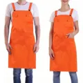 Adjustable polyester work apron with pockets, perfect for restaurant waiters and cooking use. - Orange