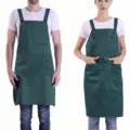 Adjustable green work apron detail featuring multiple pockets and durable fabric for use. - Dark Green
