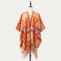 Stylish women's knitted poncho shawl with geometric pattern and cozy fringe design. - Geometric Peaks Orange