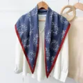 Detailed view of blue floral triangular silk scarf with red border, stylish neck accessory. - RY-31