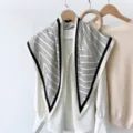 Close-up detail of a chic black and white striped triangle scarf styled on a white blouse. - RY-12