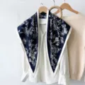 Detailed view of a retro floral silk triangular scarf draped on a chic white blouse. - RY-19