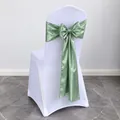 Sage green satin chair sash tied in a decorative bow for wedding banquet decor - Grass Green