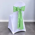 Light green satin chair sash with a large bow tied on a white banquet chair cover - Apple Green
