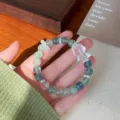 Close-up view of mint green natural fluorite bead bracelet with a cute carved crystal bear. - Bear Style