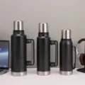 Detail view of large capacity insulated water bottles with handles and stainless steel lids. - 1000ml / Black