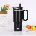 Detail view of black stainless steel insulated tumbler with straw and handle for cold drinks. - Black