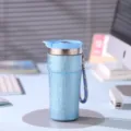 Gros plan sur la tasse isolante en titane bleu portable avec lanière pratique pour un usage quotidien. - 500ml / Bleu sarcelle