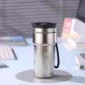 Gros plan détaillé du gobelet thermos en titane argenté avec couvercle noir sur le bureau de travail. - 500ml / Couleur Argent Originale