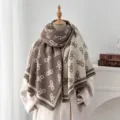 Elegante Detailansicht des dicken Jacquard-Buchstaben-Schals mit Fransen auf einer Schaufensterpuppe - Grau Kaffee