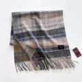 Primer plano detallado de una bufanda de lana a cuadros con flecos y marca propia - Cuadros Gris Azul Beige Café / 55x200cm