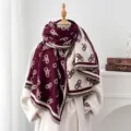 Makro-Detail eines doppelseitigen Jacquardschals in Burgund und Creme mit Fransen - Burgunderrot