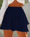 Primo piano dettaglio di pantaloncini gonna donna vita alta tinta unita a strati blu marino. - Blu navy