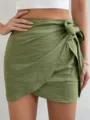 Detalle en primer plano de minifalda cruzada verde oliva de tiro alto con lazo lateral. - S / Verde Militar