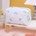 Trousse de maquillage matelassée avec nœuds bleus, pochette de rangement mignonne pour voyage. - Fond Blanc Nœud Bleu