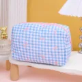 Trousse de toilette matelassée à carreaux bleus et blancs avec nœuds roses et fermeture. - Fond bleu avec nœud rose