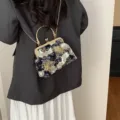 Elegante borsa a conchiglia ricamata nera con motivo a gru e catena dorata lucida - Viola