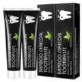 Bamboo charcoal toothpaste detail view showing 105g tubes and boxes with mint flavor and whitening effect. - White