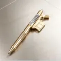 Close-up van de creatieve metalen pen in de vorm van een geweer met fijne details. - 0.5mm Blauwe Inkt / Weapon King uitwisbare pen - Luxe goud