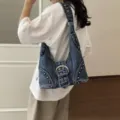 Vintage distressed denim shoulder bag featuring punk rivets and a large metal buckle - Dark Blue