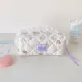 Close-up of quilted cream pencil bag with delicate white lace trim and bear pattern - Taro Bear Cosmetic Bag