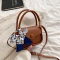 Stilvolle braune Satteltasche mit dekorativem blau gemustertem Seidenschal und Griff - Braun