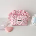 Détail d'une trousse à maquillage matelassée rose à carreaux avec fraises et volants - Rose Fraise