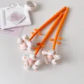 Detailed close-up of three vibrant orange gel pens featuring cute fabric flower toppers - 1PC / Orange