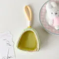 Detail view of green plush doll display bag with transparent window and handle - Green