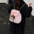 Stylischer rosa Kunstpelz-Rucksack für Damen mit niedlichem Plüschmonster-Anhänger - Mit Anhänger / Rosa