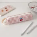 Dettaglio dell'astuccio a quadretti rosa con toppa a forma di ciliegia e cerniera color crema - Quadri Rosa